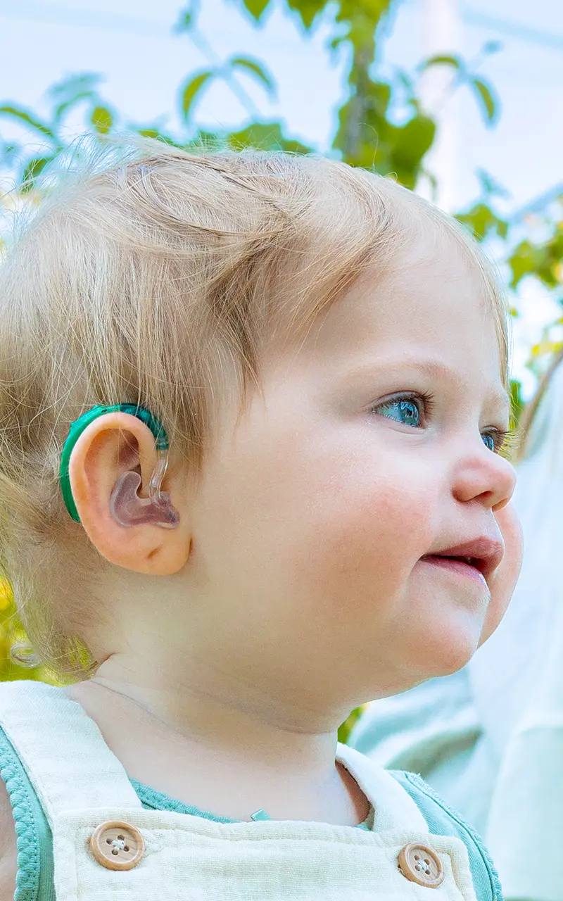 Einem Kind wird ein Hörsystem angelegt.